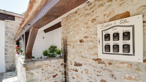 Pared de piedra con un letrero que enumera nombres de habitaciones y una estructura de vigas de madera encima.