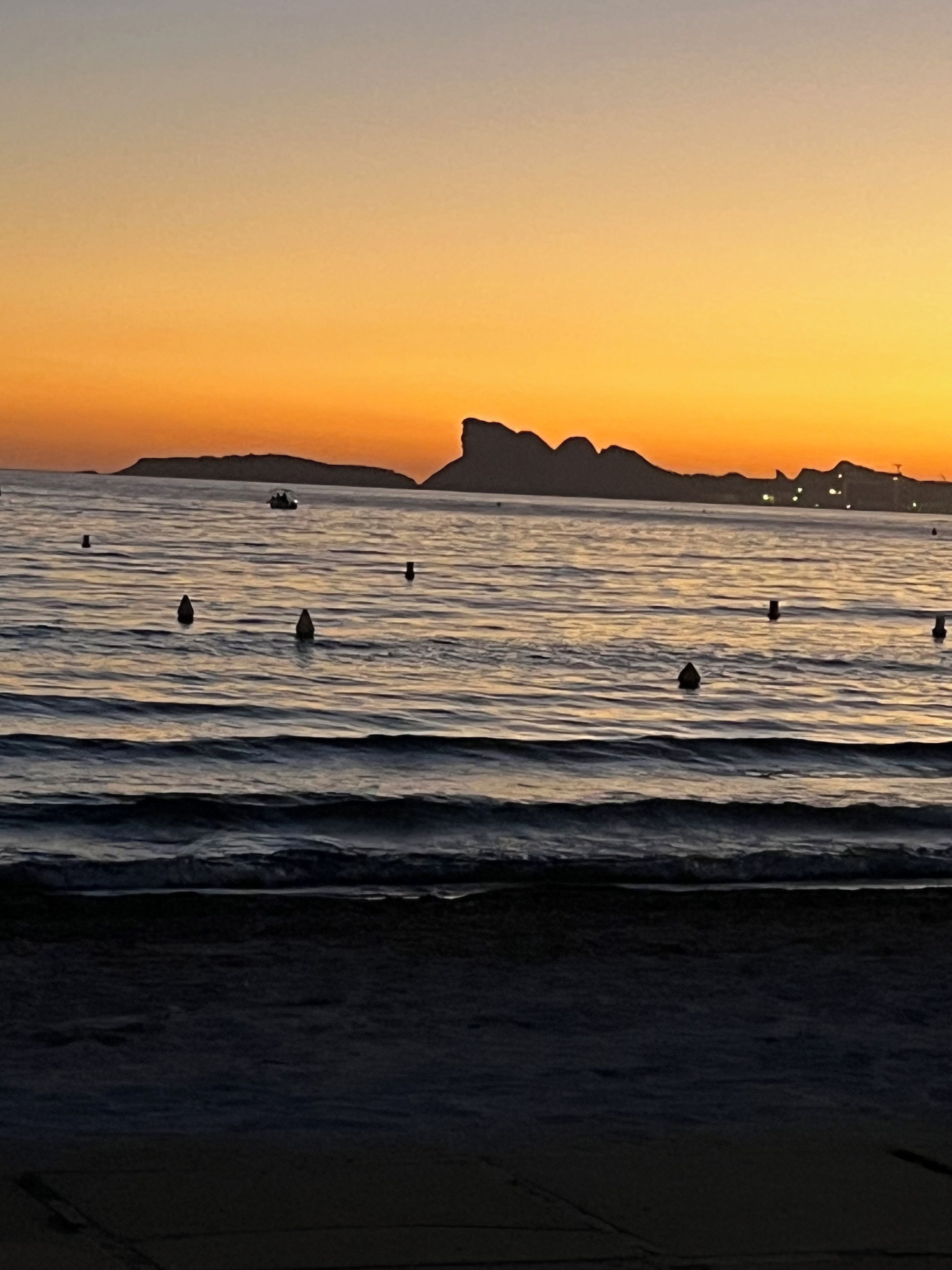 Una playa con olas y un atardecer.