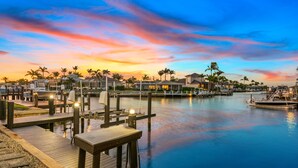 A marina with docked boats, a wooden pier, and waterfront villas with palm trees. - Waterview 3 ensuite home with pool 
HGTV chose as ideal vacation home! (Marco Island)