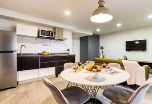 Una cocina moderna con comedor, televisor de pantalla plana y sofá.
