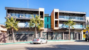 A modern building with multiple balconies, a car parked in front, and a clear blue sky. - Eazy Centro by ULIV (Tijuana)