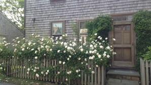A house with a wooden fence and climbing roses. - Ten min. walk to Main St. Perfect for families/groups. Gorgeous enclosed yard. (Nantucket)