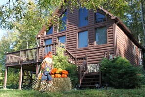 A rustic log cabin with a wooden deck and a hay bale decoration. - LAST MINUTE CANCELLATION!! FALL TIME in the smokies PET-FRIENDLY inquire today (Sevierville)