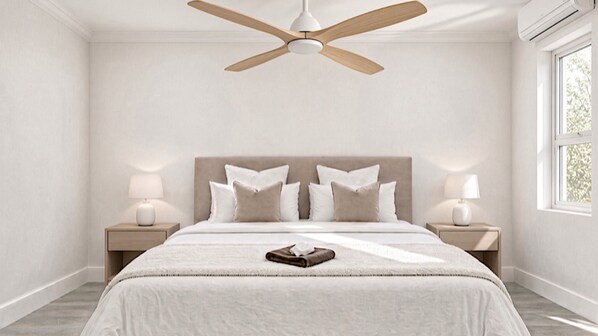 A bedroom with a bed, bedside lamps, a ceiling fan, and a window.