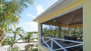 A covered outdoor area with a view of the beach and palm trees. - Lo key cottages-The Penthouse (green turtle cay)