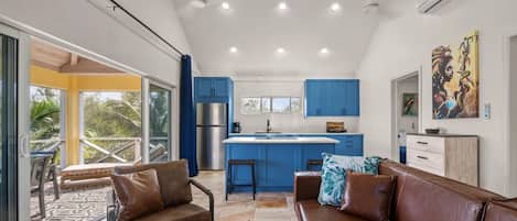 Una cocina moderna con armarios azules, una isla central y un refrigerador de acero inoxidable.