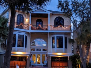 A two-story house with a balcony, large windows, and a garage.