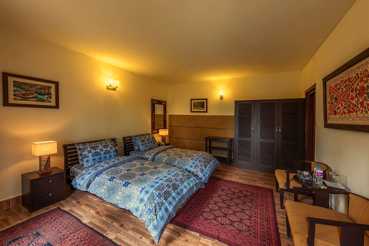 Un dormitorio con una cama, mesitas de noche, un escritorio y una silla.