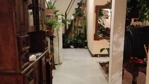 A narrow hallway with a wooden cabinet on the left and a staircase leading to another level. - Casa de Leon (Antigua Guatemala)