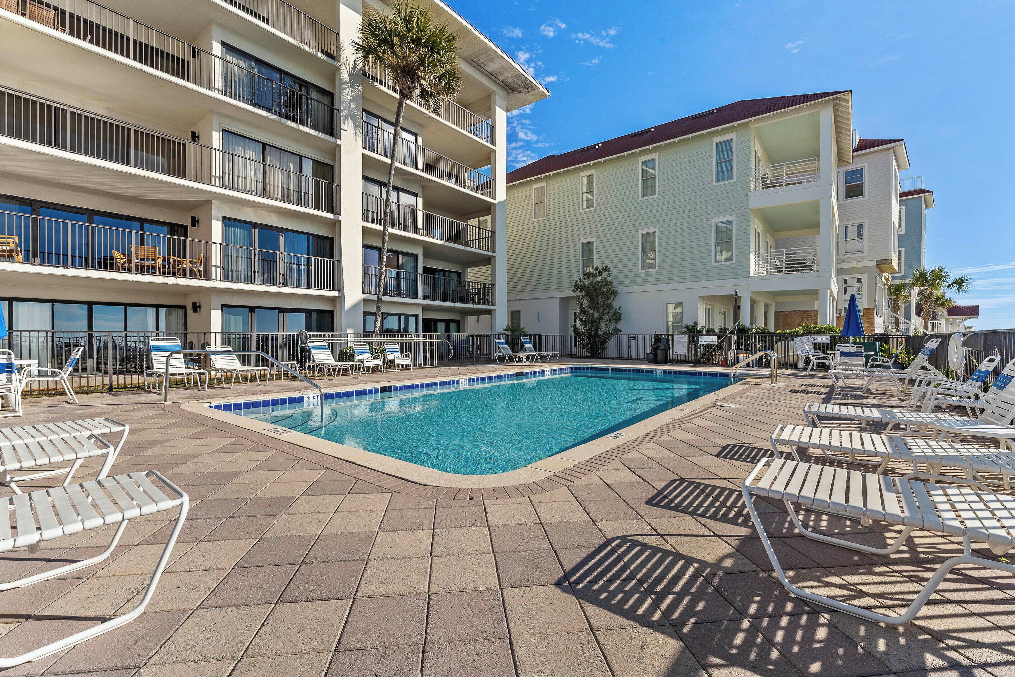 Un hôtel doté d’une piscine, de plusieurs balcons et de chaises longues.