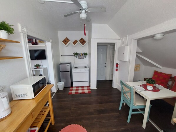 A compact kitchen with white appliances, a ceiling fan, and a red checkered rug. - Dream holiday at a great price – now with massive discounts! (Fort Myers)