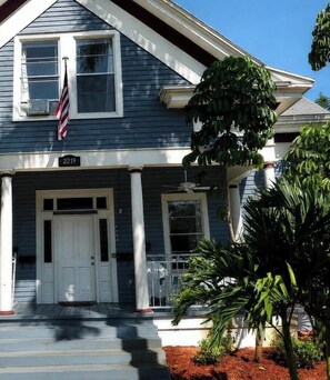 A two-story house with a front porch, white columns, and a front door.