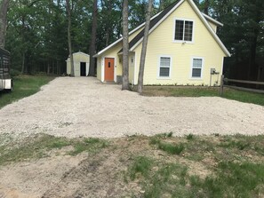A yellow building with a gravel driveway leading to a wooden door. - Couples Retreat, NEW Hot Tub 2022, ORV, Right From the Front Door (Baldwin)