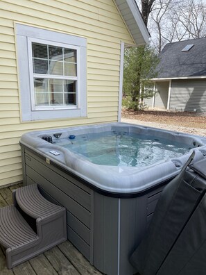 A hot tub with steps and a window, set against a house with siding. - Couples Retreat, NEW Hot Tub 2022, ORV, Right From the Front Door (Baldwin)