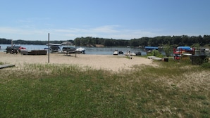 A lakeside beach with boats, a picnic table, and a covered area. - Couples Retreat, NEW Hot Tub 2022, ORV, Right From the Front Door (Baldwin)