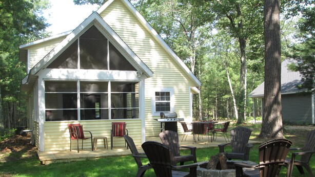 A small, single-story house with a large window and a patio area. - Couples Retreat, NEW Hot Tub 2022, ORV, Right From the Front Door (Baldwin)