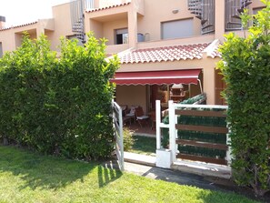 Enjoy a serene garden setting with a covered patio and outdoor furniture.