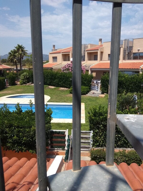 Residents enjoy a serene poolside retreat surrounded by lush greenery and a clear view.