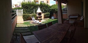Enjoy dining and socializing in this outdoor patio area with a barbecue grill and comfortable seating.