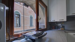 A kitchen with a large window, a countertop, and cabinets. - ZANIPOLO Marco~canal (Venezia)