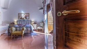 Un dormitorio con cama, una silla, una cómoda y una puerta con picaporte.