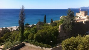 A coastal view with a beach, a fortified building, and dense greenery. - Apartment with sea view, 5 minutes from the beach (Finale Ligure)