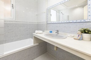 Bathtub, hair dryer, towels, shampoo