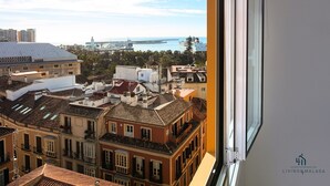 A high-rise building with a view of a coastal cityscape, including a cruise ship and a lighthouse. - Alcazaba Exclusive View Living4malaga (Málaga)