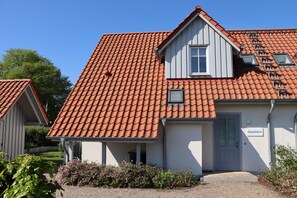 A building with a red-tiled roof, a grey door, and a sign reading "Seestern". - Semi-detached house " Seestern " on the Baltic Sea, fireplace, sauna, free WLAN -SEASIDE- (Rosenhagen)