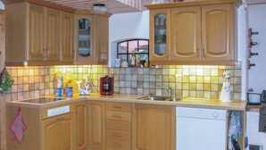 A kitchen with wooden cabinets, a dishwasher, and a coffee maker. - 2 bedroom pet friendly home in Degeberga (Degeberga)
