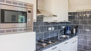 A modern kitchen with a built-in microwave, gas stove, and a coffee maker. - Stunning home in Den Ham with WiFi (Den Ham)