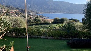 A wooden deck with a metal pole, overlooking a lake and mountains. - CHARMING VILLA,UP-MARKET,PANORAMIC SEA VIEW, 3MN WALK TO A BEAUTIFUL SAND BEACH (Casaglione)