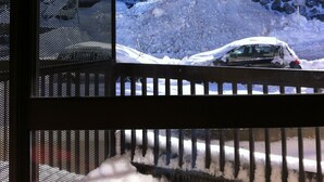 A snow-covered outdoor area with a staircase leading up to a stone wall.