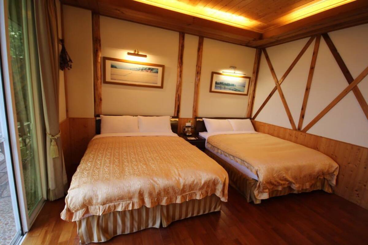 Una habitación con dos camas, paredes de madera y cuadros en la pared.
