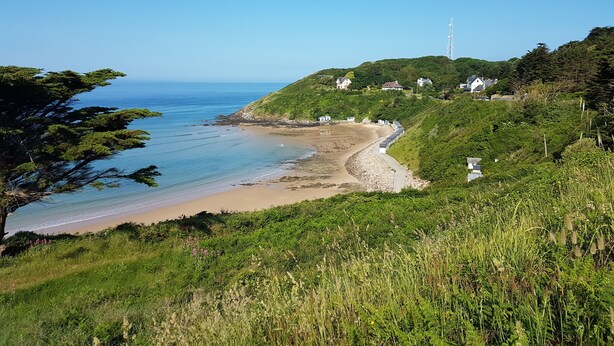 A coastal landscape with a beach, houses on a hillside, and a transmission tower. - the charm of Normandy between sea and countryside (Les Moitiers-D'allonne)