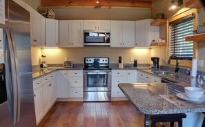 Enjoy cooking in this well-equipped kitchen with a stove, refrigerator, and microwave, plus ample workspace at the large island.