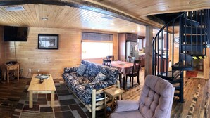 Un interior de madera con sofá, mesa y una escalera.