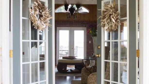 A home entrance with two glass doors, a wooden floor, a doormat, and a ceiling fan. - Panoramic Water Views, Deep Water Dock, Right outside Your Doors! (Midway)