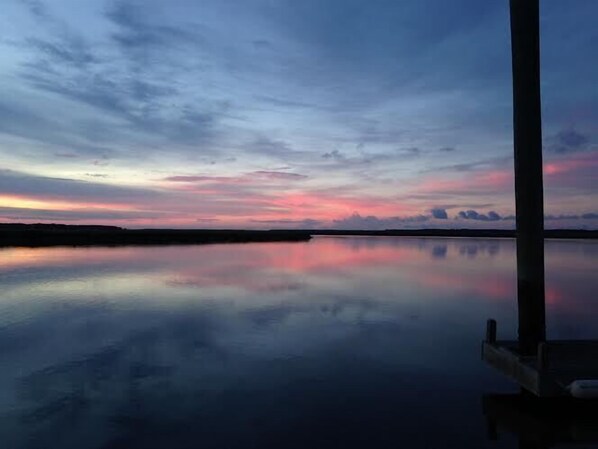 A calm body of water reflecting a sunset sky.