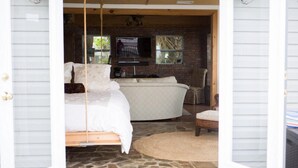 A bedroom with a bed, a chair, a small table, and a TV. - Panoramic Water Views, Deep Water Dock, Right outside Your Doors! (Midway)