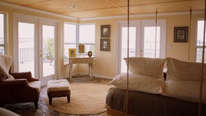 A room with a bed, a chair, a desk, and a view of the outdoors. - Panoramic Water Views, Deep Water Dock, Right outside Your Doors! (Midway)