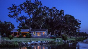 A lakeside house with a porch, a small dock, and a pond in front. - Panoramic Water Views, Deep Water Dock, Right outside Your Doors! (Midway)