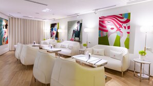 A modern hotel room with a sofa, chairs, a small table, and a lamp. - Chao Motel (Taoyuan City)
