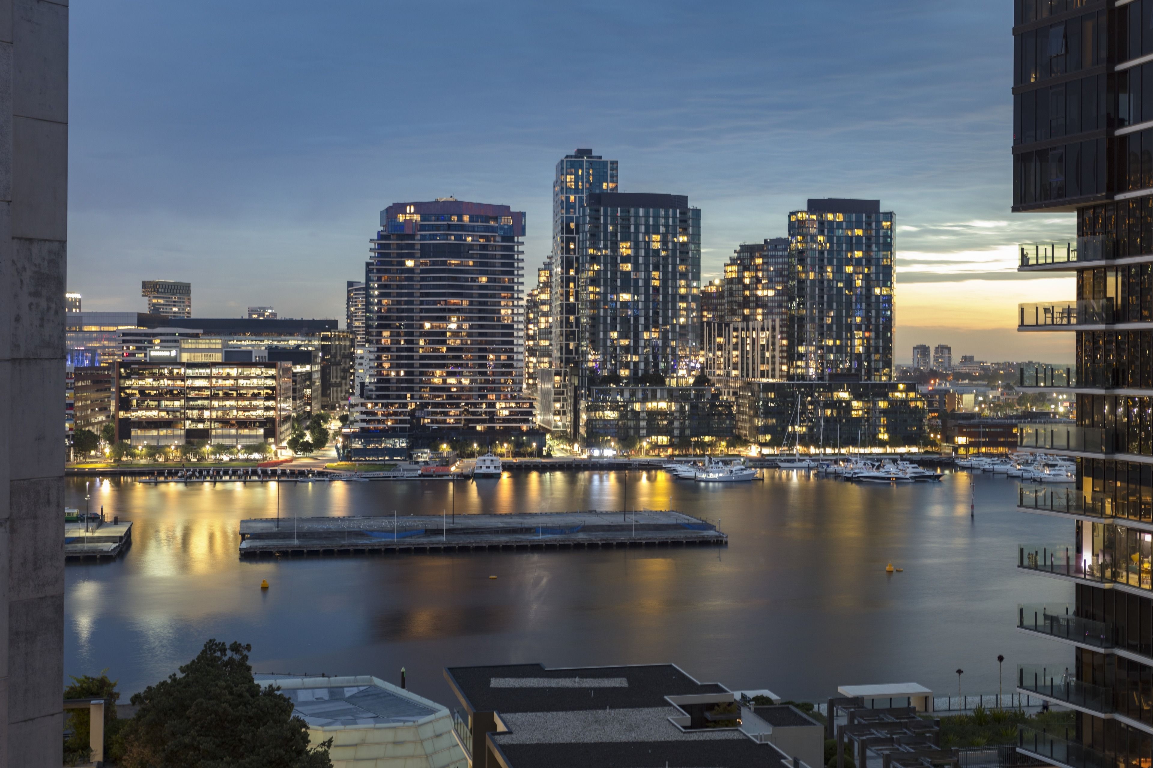A waterfront cityscape with high-rise buildings and a marina.
