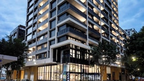A modern high-rise building with multiple balconies and a ground-level entrance labeled "QUEST." - Quest NewQuay (Docklands)