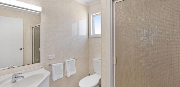 Un baño con bañera, inodoro y ventana.