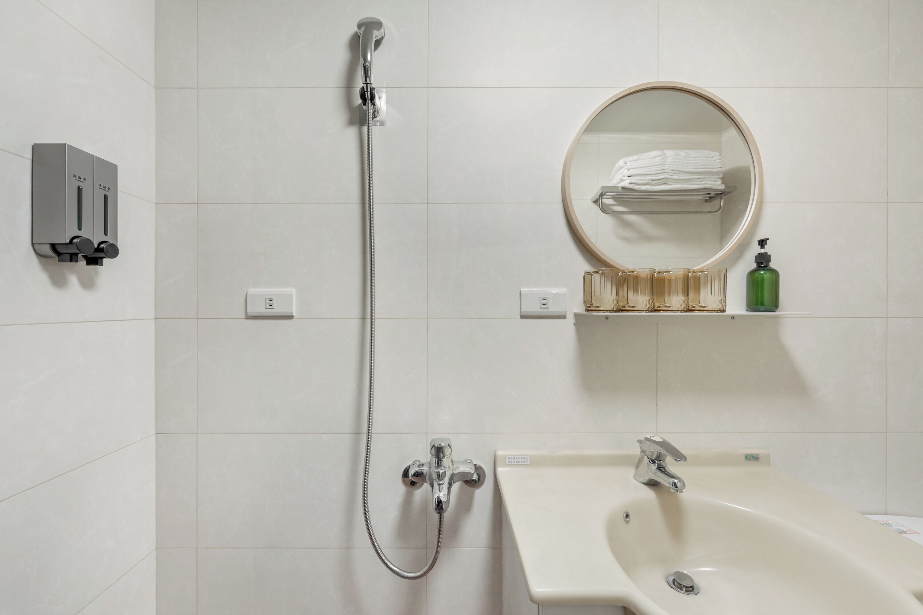 Une salle de bain avec une douche, un lavabo et un miroir.