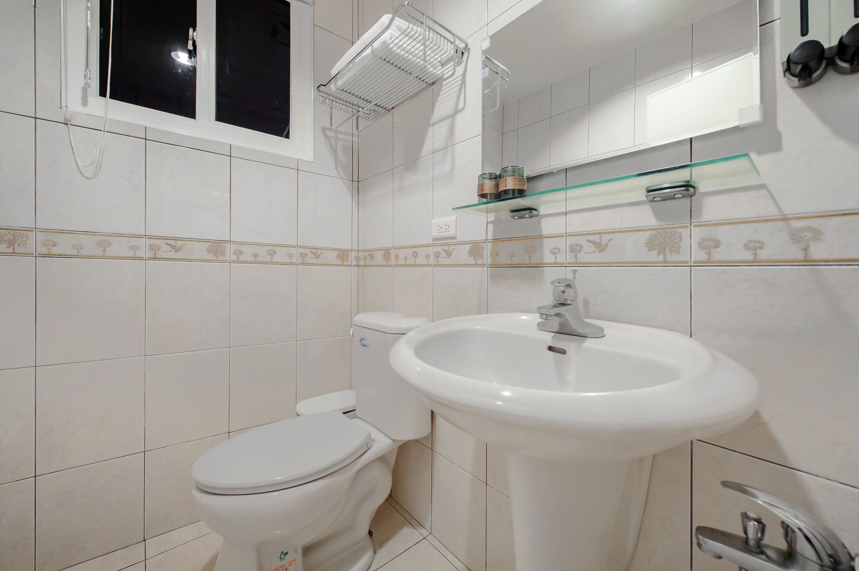 Ein Badezimmer mit Toilette, Waschbecken und Fenster.