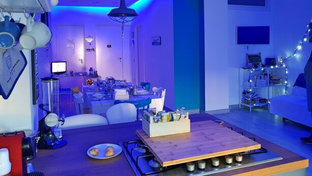 Eine moderne Küche mit Essbereich, einer Kaffeemaschine und einem Holztisch mit einer Teller voller Speisen.