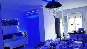 Ein modernes Wohnzimmer mit Sofa, Esstisch und einem Weihnachtsbaum.